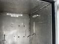Interior of a metal compartment from a 2009 Morgan Olson Workhorse featuring a hanging hook and a light fixture with an expiration date label for oxygen and acetylene hoses