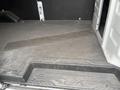 Interior floor of a 2023 Ford Transit showing a rubberized surface and a step leading into the cargo area