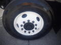 Close-up of a black tire mounted on a white wheel with multiple bolt holes featuring the brand name Goodyear prominently displayed on the sidewall