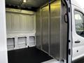 A 2017 Ford Transit with an open cargo area featuring metal walls and a black floor