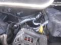 Close-up of the engine components of a 2016 Ford Transit showing various hoses and the alternator