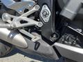 Close-up of a 2018 Triumph Street Triple RS motorcycle's footpeg and gear shift lever with a metal and black casing design