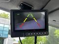 A monitor displaying a rearview camera feed with colored guidelines indicating distance and direction for parking safety