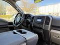 Interior view of a 2018 Ford F-150 showcasing the steering wheel dashboard and console with controls and display screen