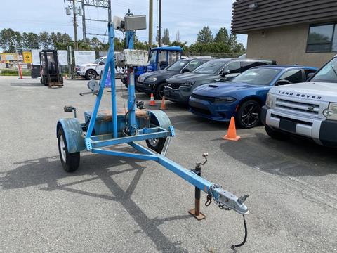 A blue 2003 U-Built Reel Trailer with a vertical post carrying a light fixture and a hitch on the front for towing