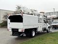 A white 2015 Ford F750 bucket truck with an elevated work platform and a large rear compartment for equipment storage