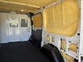 Interior of a 2016 Ford Transit van with yellow insulation lining the walls and a black floor featuring metal partitions separating the front and rear cargo areas
