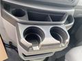 Cup holder console in a 2009 Ford Econoline with two cup holders and additional storage compartments