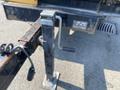 A metallic hydraulic lift with a crank handle attached to a trailer hitch