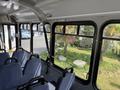 Interior of a 2017 Chevrolet Express featuring blue fabric seats with metal armrests and large windows allowing natural light in