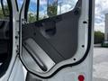 The image shows the open door of a 2010 Freightliner M2 106 featuring a gray interior panel with a handle and a built-in storage area