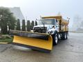 A 2016 International 7400 truck with a large yellow snow plow attached to the front and a dump bed at the rear