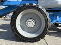 A close-up of the tire of a 2012 Genie Z 45/25 with a grey rim and black tread showcasing the brand name and model details