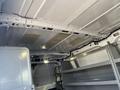 Interior of a 2016 Ford Transit van showing the metal ceiling and storage shelves on the sides