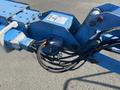 A blue 1997 Genie S-65 4X4 aerial lift with hydraulic hoses and components visible on the framework