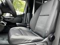 A comfortable driver's seat in a 2023 Mercedes-Benz Sprinter with a modern interior design featuring adjustable controls and ergonomic support