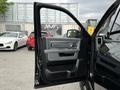 A 2018 RAM 1500 with its driver's side door open displaying the interior door panel and controls