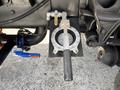 A mechanical component mounted on the underside of a 2015 Ford F-750 featuring a circular plate with a handle and pipes connected to it