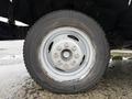 Close-up of a silver wheel with five bolts on a black tire from a 2012 Ford Econoline