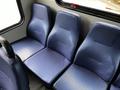 Three blue, textured seats arranged next to each other inside a Chevrolet Express