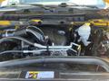 Engine compartment of a 2015 RAM 1500 featuring a large black engine cover various hoses and components in a clean layout
