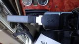 A gear shift lever from a 2003 International 5600i truck with a black handle and silver metal shaft displaying various markings and a textured grip