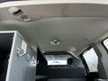 Interior view of a 2011 Dodge Grand Caravan showing the ceiling and part of a partition with storage compartments and hooks visible