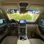 Interior of a 2022 Toyota Land Cruiser GXR featuring a dashboard with a large touchscreen display and a leather-trimmed steering wheel