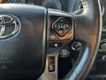 Close-up of the steering wheel controls of a 2021 Toyota Tacoma featuring buttons for navigation and audio settings