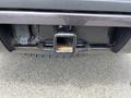 A 2016 Chevrolet Tahoe trailer hitch receiver with a visible plug connection and some rust on the metal