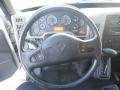 The interior of a 2014 International Durastar featuring a steering wheel with control buttons and a dashboard displaying various gauges and an illuminated screen