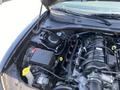 The image shows the engine compartment of a 2019 Dodge Charger with visible engine components and battery along with various hoses and connectors