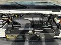 Close-up of the engine compartment of a 2004 Ford Econoline displaying the air intake and various components including hoses and battery without any visible labels or markings