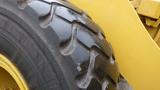 Close-up of a large, heavy-duty tire from a 2019 Caterpillar 972M XE featuring a rugged tread pattern designed for traction and durability