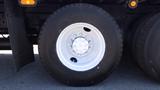 A close-up of a white wheel on a 2017 Freightliner M2 106 featuring a black tire with a distinctive tread pattern and multiple lug bolts