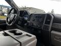 Interior view of a 2019 Ford F-550 showcasing the dashboard controls cup holders and infotainment system