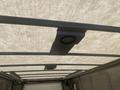 A 2012 Ford Econoline with a white cargo area roof and metal ribs supporting the structure