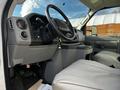 Interior view of a 2013 Ford Econoline van showing the driver's seat dashboard and steering wheel