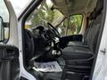 Interior of a 2019 RAM Promaster showing the driver's seat dashboard and passenger seating area with fabric upholstery and floor mats