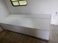 A white storage bench with a flat top located inside a 2004 Royal 18 Foot Office Trailer