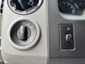 A control panel from a 2014 Ford E-350 featuring a headlight switch and an adjustable dial for various light settings