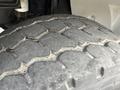 Close-up of a worn tire with distinct tread patterns from a 1998 Freightliner FL80 showing deep grooves and surface wear
