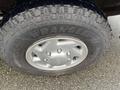 The close-up view of a tire on a 2006 Ford Econoline displaying a Wrangler brand tire tread with visible water droplets on the surface