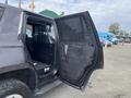 A 2016 Chevrolet Tahoe with an open door featuring a metal mesh barrier and a black interior space designed for secure transport