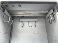 Interior of a 2012 Freightliner M2 106 showing a metal shelving unit with multiple hooks mounted on the walls for storage purposes