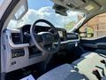 Interior view of a 2023 Ford F-550 showing the steering wheel dashboard and seats with a modern design and touchscreen display