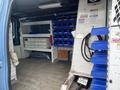 Interior of a 2010 Ford Econoline van featuring shelving units storage bins and equipment compartments