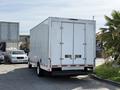 A white 2019 Ford Econoline cargo van with dual rear doors is parked with its back facing the viewer
