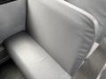 A gray fabric bus seat with a textured surface and a smooth, padded backrest designed for passenger comfort