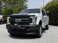 A 2017 Ford F-250 SD in white with a black front grille and heavy-duty front bumper equipped with a winch and off-road tires